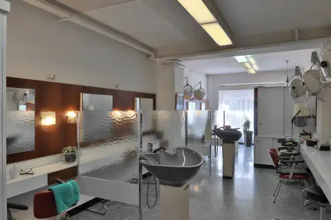 Interior del salón con lavacabezas, espejos y luz de mediodía
