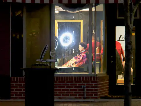 Escaparate iluminado del local visto desde la calle de noche