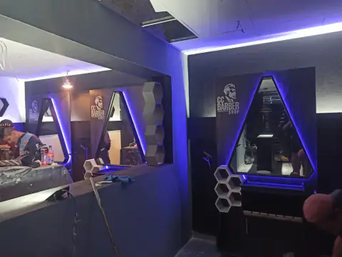 Puestos de trabajo con los espejos iluminados en azul sobre pared oscura